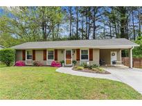 Charming single-story home with a landscaped yard, carport, and freshly painted facade at 3048 Cottonwood Se Dr, Atlanta, GA 30316