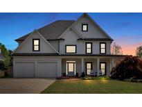 Charming two-story home featuring a well-manicured lawn and a welcoming front porch with seating at 541 Lombard St, Marietta, GA 30064