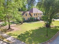 Inviting two-story home with a well-manicured lawn and mature trees surrounding the property at 7389 Tidewater Trce, Stone Mountain, GA 30087