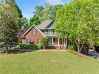 Charming brick home featuring manicured landscaping and a welcoming front porch at 204 Overland Trl, Mcdonough, GA 30252