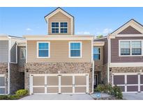 Charming townhome featuring a two-car garage, brick accents, and a neatly maintained front lawn at 38 Trailview Ln, Hiram, GA 30141