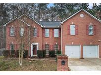 Charming two-story brick home with a well-manicured lawn and red shutters at 1086 Deshon Trl, Lithonia, GA 30058