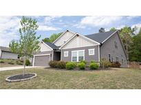 Charming home with gray siding, white trim, a well-manicured lawn, and a two-car garage at 6340 Arlington Cir, Cumming, GA 30041