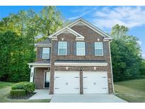 Charming brick two-story home with attached two-car garage and beautifully manicured lawn at 739 Rolling Downs Dr, Loganville, GA 30052