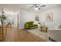 Inviting living room featuring a stylish green sofa, wood floors, and natural light at 2294 Salt Springs Pl, Austell, GA 30168