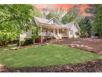 Charming home with a welcoming front porch and beautifully landscaped front yard at 415 Morgan Falls Chase, Canton, GA 30114