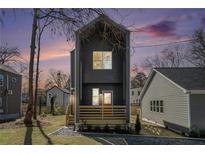 Modern two-story home with gray siding, wooden deck and front yard, set against a sunset-colored sky at 100 Dahlia Sw Ave, Atlanta, GA 30314