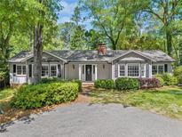 Charming one-story home with a well-manicured lawn, mature trees, and a welcoming front porch at 3150 Rilman Nw Rd, Atlanta, GA 30327