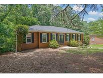 Charming brick ranch-style home featuring a well-maintained lawn and a new roof surrounded by mature trees at 486 Edward Ct, Marietta, GA 30066