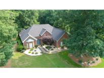 Well-maintained brick home with a landscaped front yard, mature trees, and a welcoming entrance at 235 Huiet Dr, Mcdonough, GA 30252