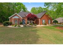Charming brick home featuring manicured landscaping and a well-maintained lawn at 235 Huiet Dr, Mcdonough, GA 30252