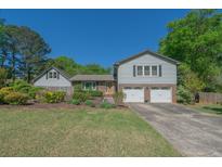 Charming home featuring a well-maintained lawn, mature landscaping, and a two-car garage at 2921 Huntcliff Dr, Marietta, GA 30066