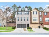 Well-manicured townhome showcasing a welcoming two-car garage and detailed architectural design at 3229 Hallmark Ln, Buford, GA 30519