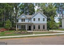 Charming two-story home showcasing light blue siding, brick accents, and a well-manicured front yard at 4549 Ajo Lot#30 Walk, Atlanta, GA 30331