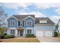 Charming two-story home with a well-manicured lawn, a two-car garage and a welcoming front porch at 520 Tackett Farms Rd, Smyrna, GA 30082