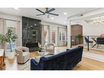 Bright living room with a fireplace, modern ceiling fan, and beautiful hardwood flooring at 1906 Variations Ne Dr, Atlanta, GA 30329