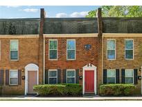 Charming brick townhome featuring a well-maintained lawn and colorful front door at 135 N North River Dr, Atlanta, GA 30350