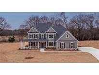 Inviting two-story home featuring a covered front porch and a well-manicured lawn at 175 Paislee Park (Lot # 11 Paislee Park) Dr, Fayetteville, GA 30215