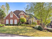 Stunning brick home with manicured lawn and lush landscaping, creating a picturesque curb appeal at 177 Grandmar Chase, Canton, GA 30115