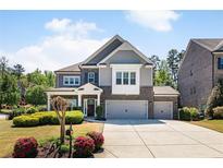 Charming two-story home with brick and siding, showcasing a well-manicured lawn and two-car garage, embodying classic suburban appeal at 1862 Lake Ebenezer Trl, Marietta, GA 30066