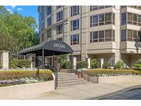 Elegant entrance to the building featuring manicured landscaping and covered drop-off area at 3475 Oak Valley Rd # Apt 650, Atlanta, GA 30326