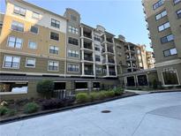 Low angle shows the tan facade of a mid-rise residential building with balconies at 799 Hammond Dr # 321, Atlanta, GA 30328