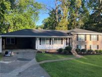 Charming single-Gathering home featuring brick and siding, a lush lawn, and a covered carport at 3925 Chicamauga Ne Dr, Kennesaw, GA 30144
