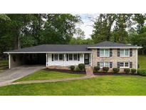 Charming brick home with a well-manicured lawn and a covered carport at 3925 Chicamauga Ne Dr, Kennesaw, GA 30144