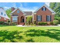 Charming brick home featuring manicured lawn, beautiful landscaping, and inviting entryway at 1272 Saxony Se Dr, Conyers, GA 30013