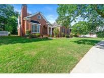 Charming brick home featuring a well-manicured lawn, mature trees, and classic architectural details at 1272 Saxony Se Dr, Conyers, GA 30013