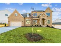 Charming brick home features a stone accent facade, manicured lawn, and attached two-car garage at 2019 Fern Mountain Ln, Marietta, GA 30064