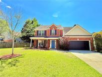 Charming two-story brick home featuring a well-manicured lawn and a two-car garage at 3049 Battlement, Loganville, GA 30052