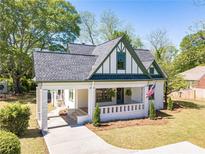Charming two-story home with a landscaped yard, covered porch, and beautifully painted in cream and green at 181 W Hightower Trl, Social Circle, GA 30025