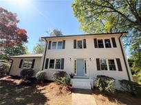 Charming two-story home with a brick facade, black shutters, and landscaped front yard at 563 Hillandale Circle Sw, Marietta, GA 30064