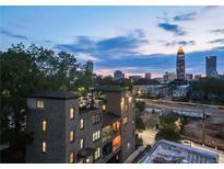 Beautiful brick home with a rooftop deck overlooking the city skyline at twilight at 631 Boulevard Ne, Atlanta, GA 30308