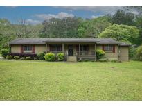 Charming single-story home with a covered front porch and well-maintained landscaping at 24 Autry Road, Auburn, GA 30011