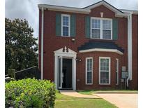 Exterior of red brick two-story house with green shutters and an open door in the front at 5897 Strathmoor Manor Cir, Lithonia, GA 30058