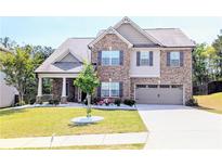 Charming two-story brick home featuring a well-manicured lawn and attached two-car garage at 3419 Mulberry Cove Way, Auburn, GA 30011