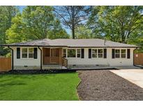Charming white-brick home featuring black shutters and a well-manicured front yard with dark mulch at 1737 Briarlake Cir, Decatur, GA 30033