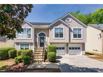 Charming two-story home featuring a two-car garage, manicured lawn and stone staircase, perfect for suburban living at 3140 Ennfield Ln, Duluth, GA 30096