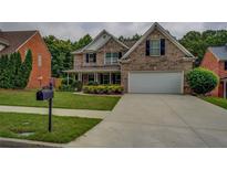 Charming two-story brick home featuring a well-manicured lawn, a two-car garage, and traditional architectural details at 1670 Cooper Lakes Dr, Grayson, GA 30017