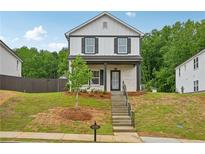 Charming two-story home featuring a classic black and white facade and well-manicured lawn at 4680 Hemingway Trl, Cumming, GA 30041