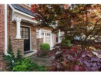 Charming townhome entrance with stone accents, black door, and lush landscaping at 5523 Glenridge Ne Park, Atlanta, GA 30342