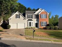 Two-story home with brick and siding, a two-car garage, and a well-manicured lawn at 4018 Dorchester Nw Walk, Kennesaw, GA 30144