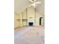 Living room featuring a fireplace, vaulted ceilings, carpeted floors, and built-in shelving at 25 Derby Dr, Hiram, GA 30141