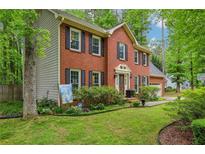 Charming two-story brick home with black shutters and a well-manicured front lawn at 1520 N Milford Creek Sw Ln, Marietta, GA 30008
