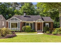 Charming brick home featuring a well-manicured lawn, complemented by lush greenery and a welcoming entrance at 333 Mimosa Dr, Decatur, GA 30030