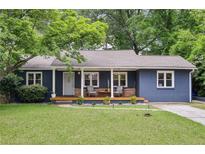 Charming blue painted brick home featuring a covered porch and a well manicured lawn at 1222 Crestwood Se Dr, Atlanta, GA 30316