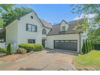 Charming two-story home with a white painted brick exterior, landscaped yard, and an attached two car garage at 1751 Bergen Ct, Lawrenceville, GA 30043