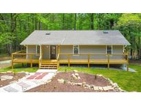 Charming home featuring a welcoming front porch and landscaped front yard in a serene setting surrounded by trees at 2633 Jonesboro Rd, Fairburn, GA 30213